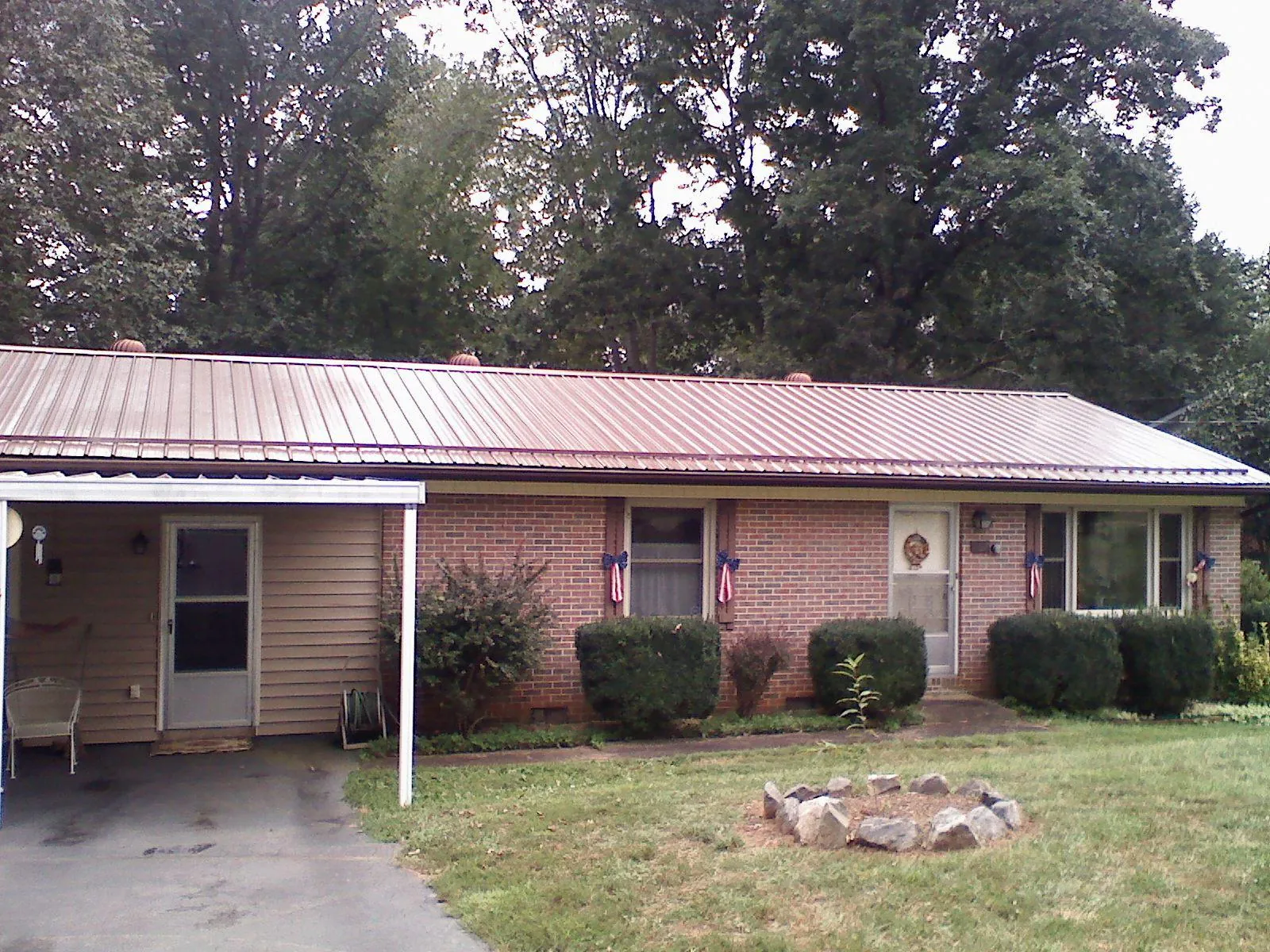 Bronze metal roof and carport on a brick ranch home — Roof Repair work by our crew in Saint Johns